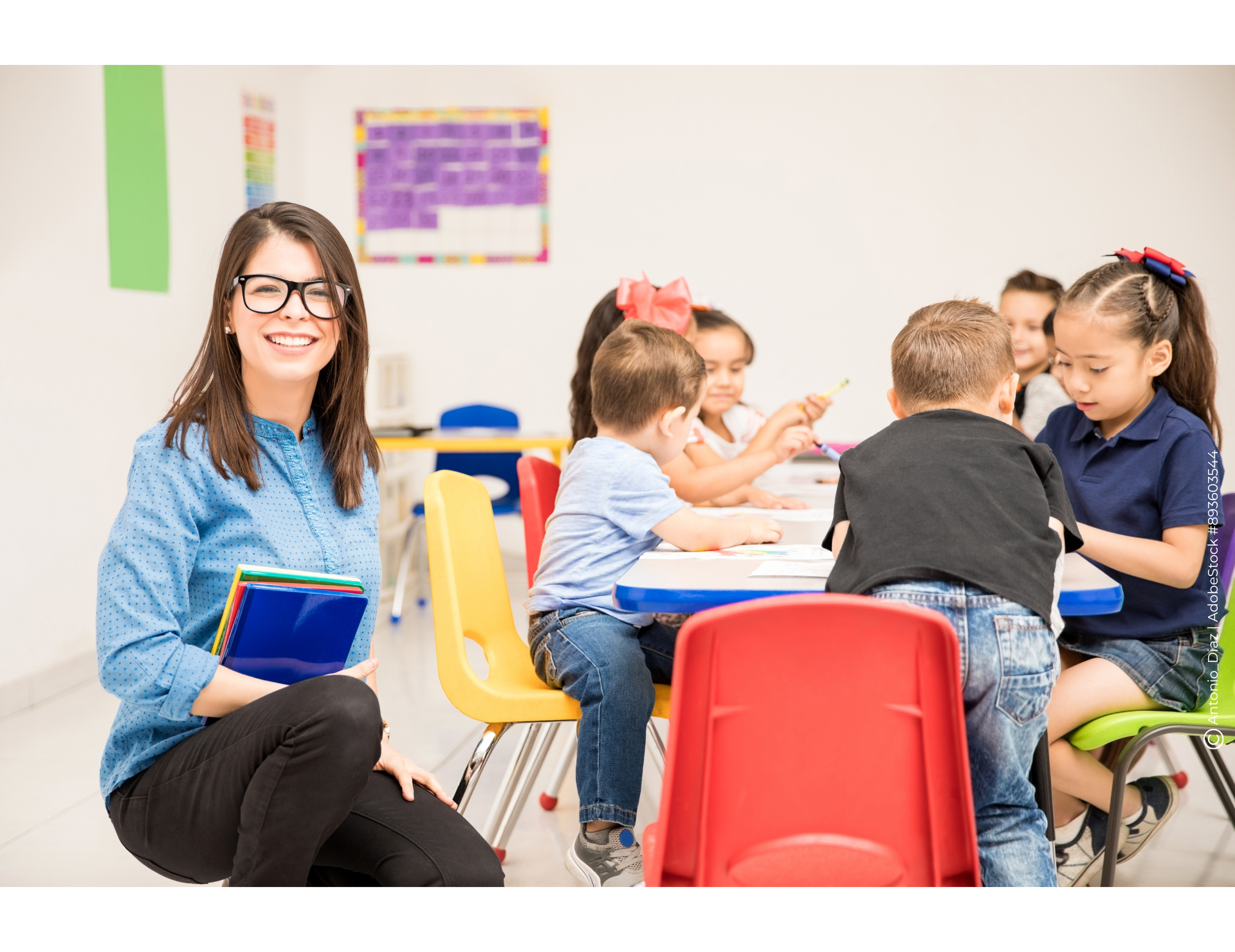 Frau neben einem Tisch mit Kindern die basteln
